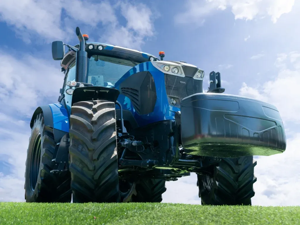 Blauer Traktor steht auf Wiese