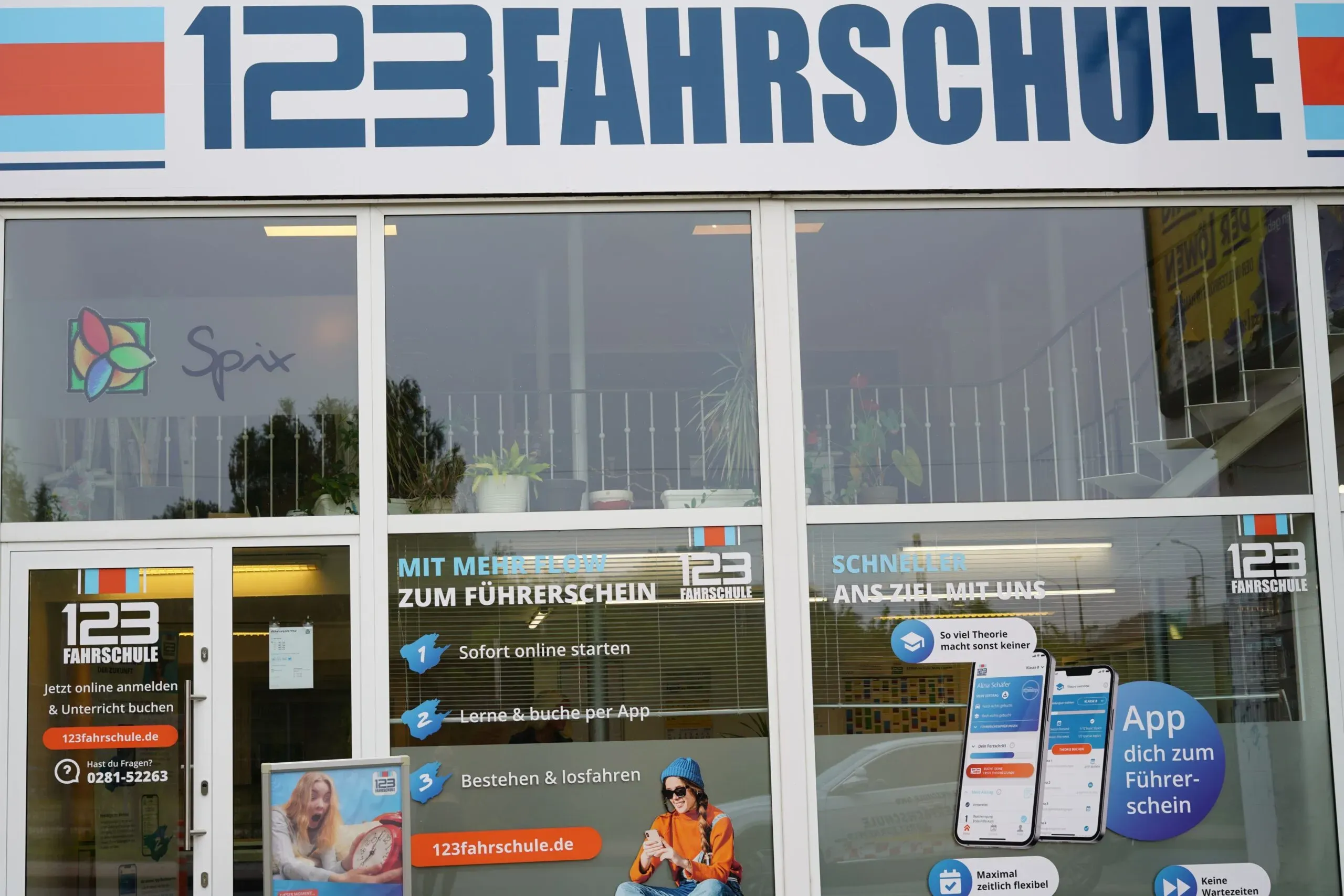 Schaufenster einer Filiale der 123 Fahrschule mit Werbebeschriftung